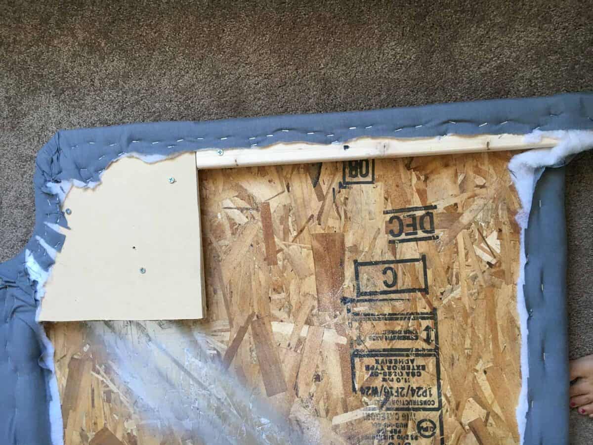 The back of the headboard with the batting and fabric attached using staples.