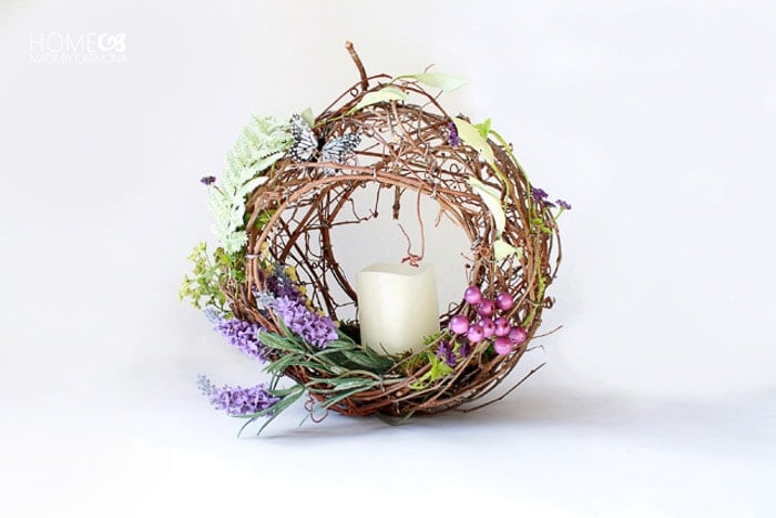 simple small wreath basket with purple and pink flowers and candle in the middle