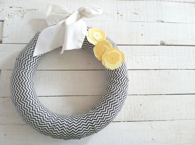 Foam wreath wrapped in zigzag fabric with yellow paper flowers and white bow
