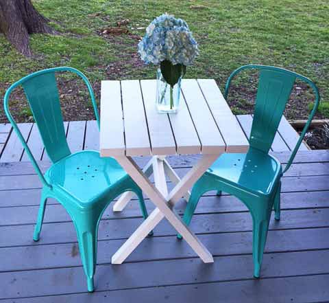 White Bistro table made from 2x4 wood with blue chairs