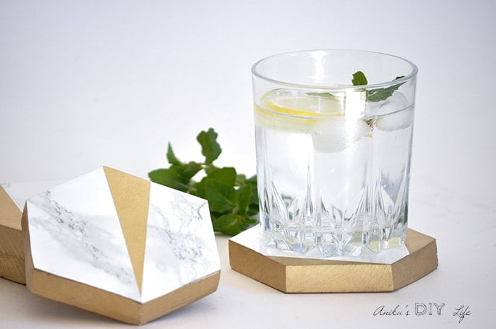 Gold and marble hexagonal coasters with a glass of water