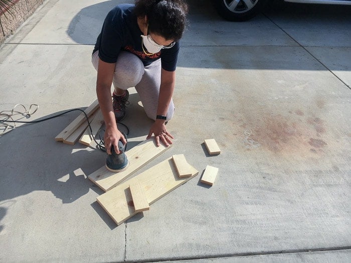 Sanding wood boards for DIY floating ladder shelf with orbital sander