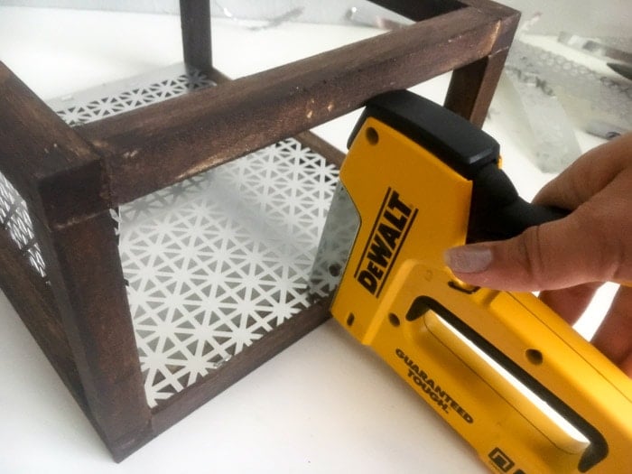 Attaching the decorative metal sheet to the wood and create a DIY wood sconce