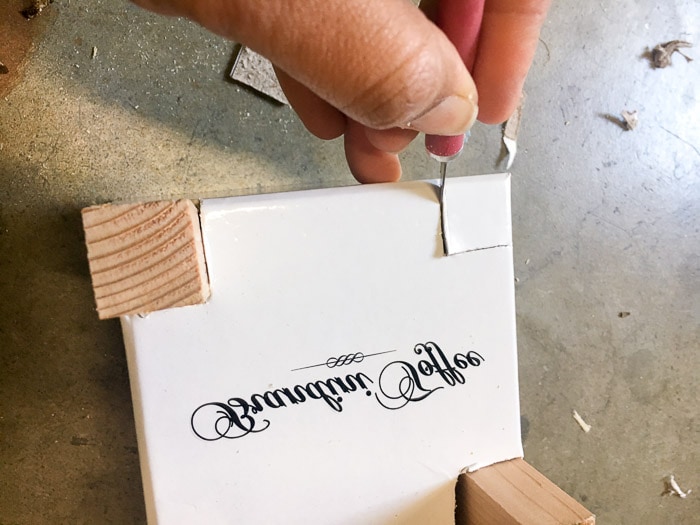 Cutting out carboard box to add wood feet for a DIY concrete planter with wood feet