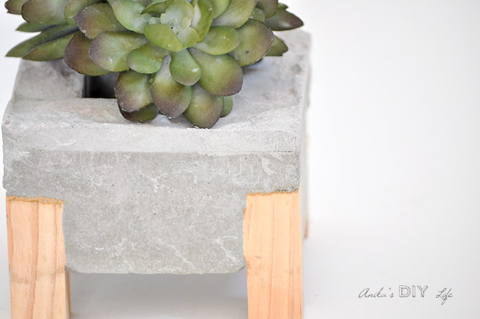 Close up view of the DIY concrete planter with wood legs