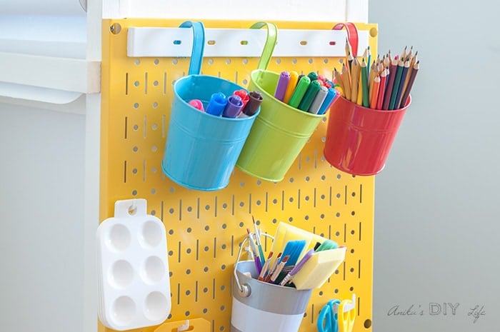 Close up of yellow Wall control metal pegboard system used in a DIY kids art station