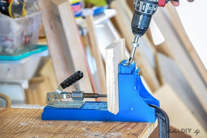 Drilling pocket holes in shelf pieces to build the DIY plant stand
