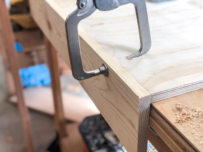 Using the edge of the workbench to assemble the sides of the DIY shoe organizer