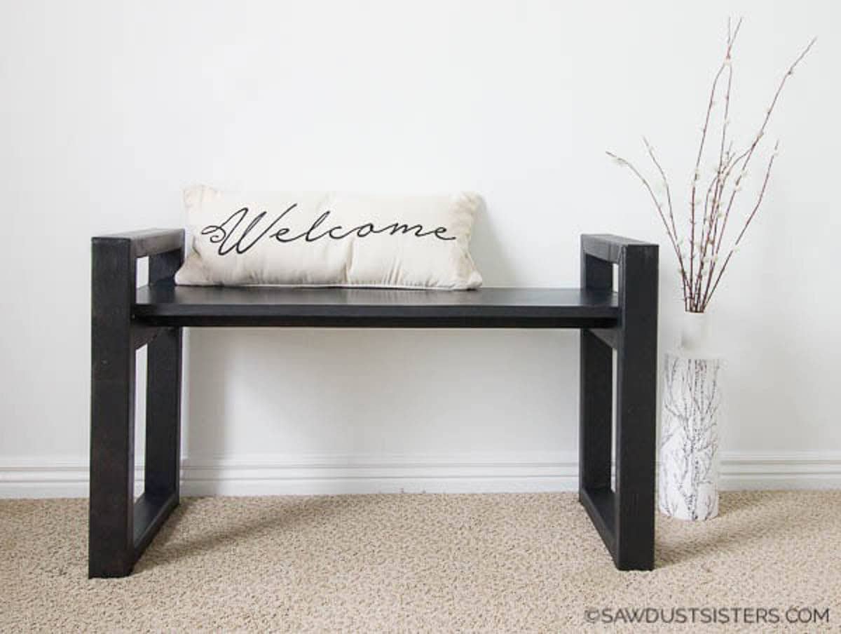 Modern style wooden bench with welcome throw pillow on the seat