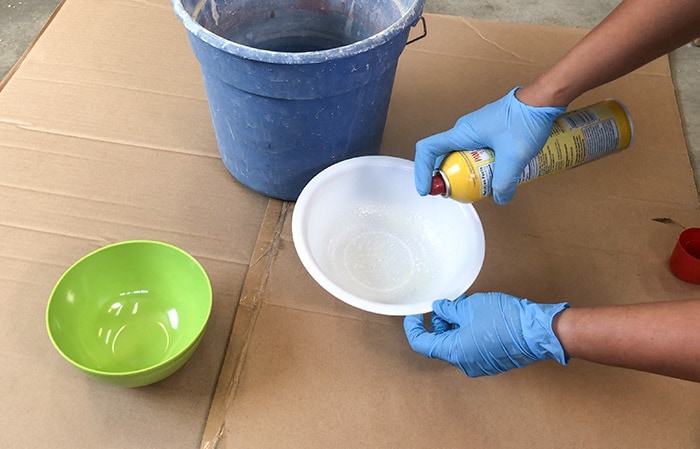 Greasing plastic bowls to make the DIY hanging concrete planter 