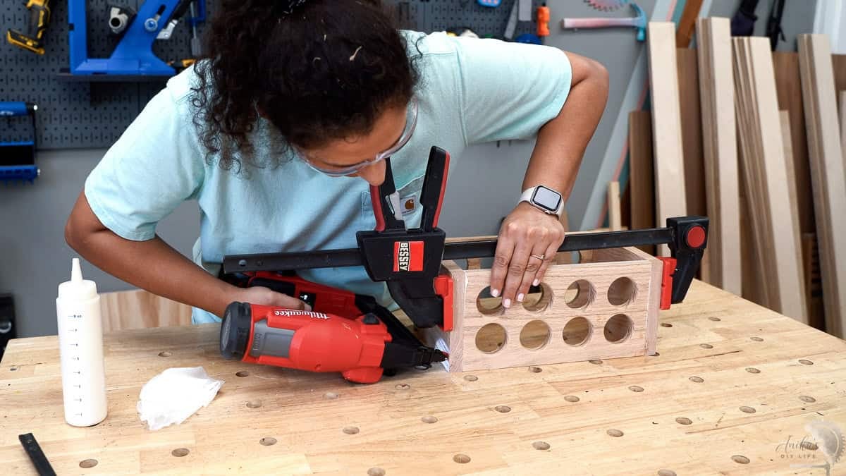 woman Attaching the parts of the diy spice rack with a nail gun