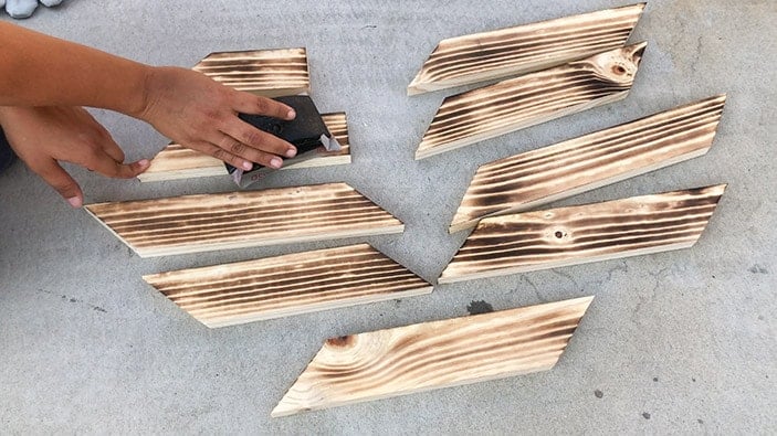 sanding boards between passes of wood burning