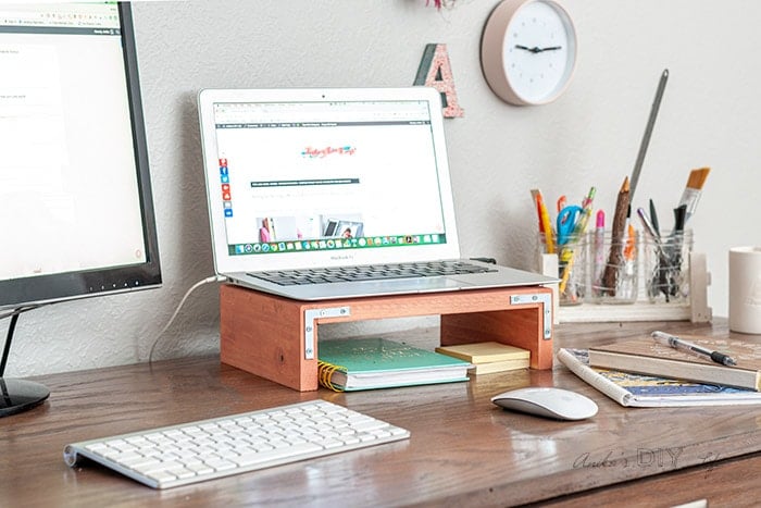 Laptop sitting on DIY laptop desk stand on a desk with keyboard and mouse