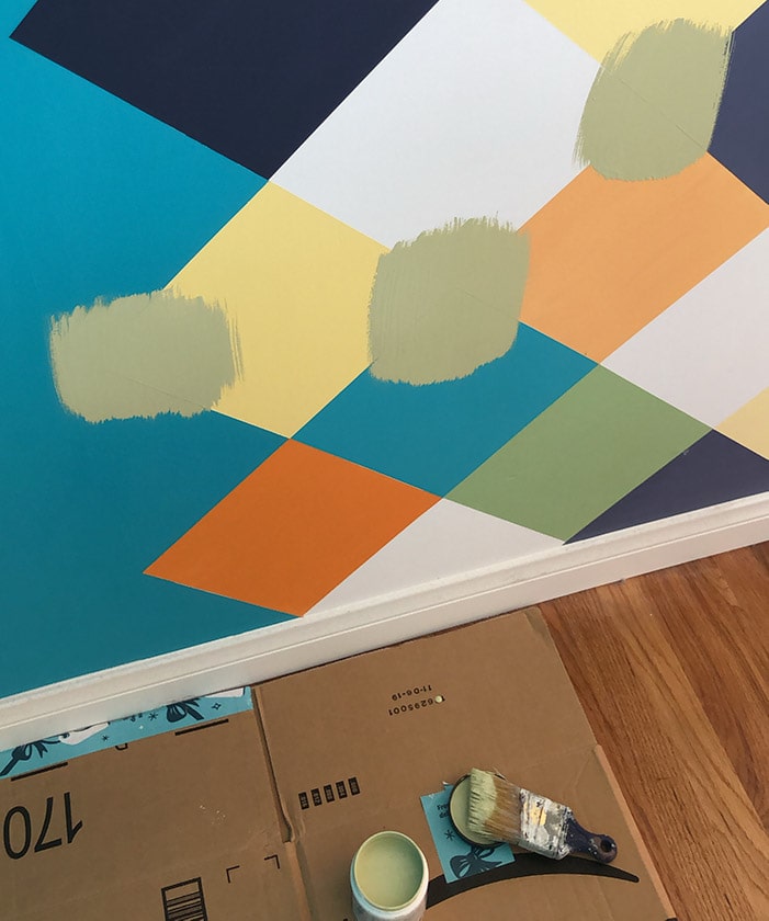 testing green paint sample on patterned wall