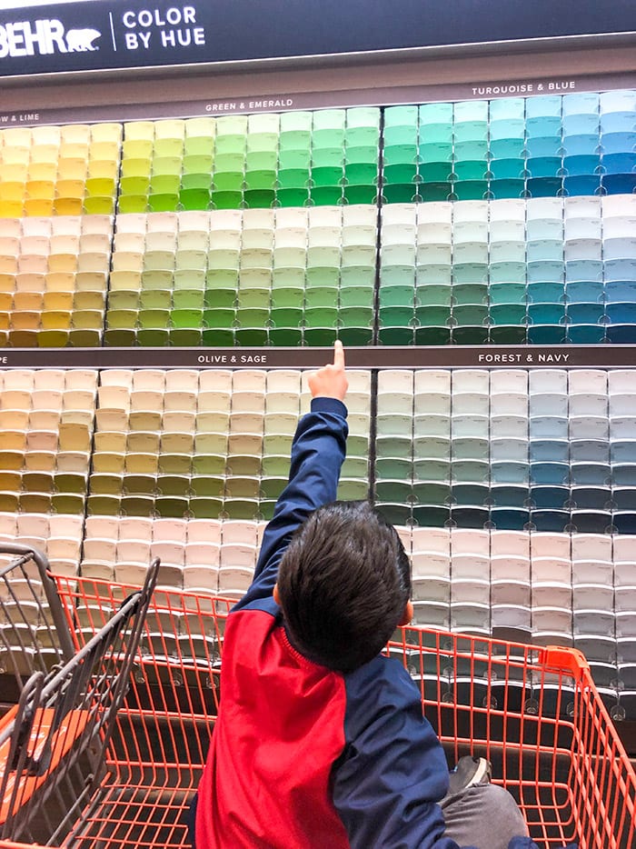 boy picking colors from wall at Home Depot