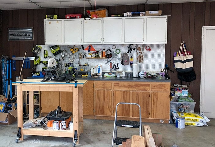 accent wall before - messy garage with cabinets and pegboard