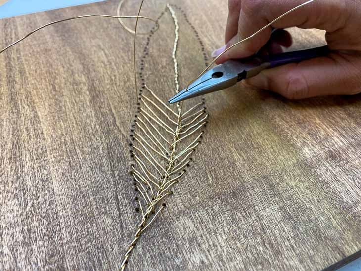 Making the vane of the feather wall art with wire on wood