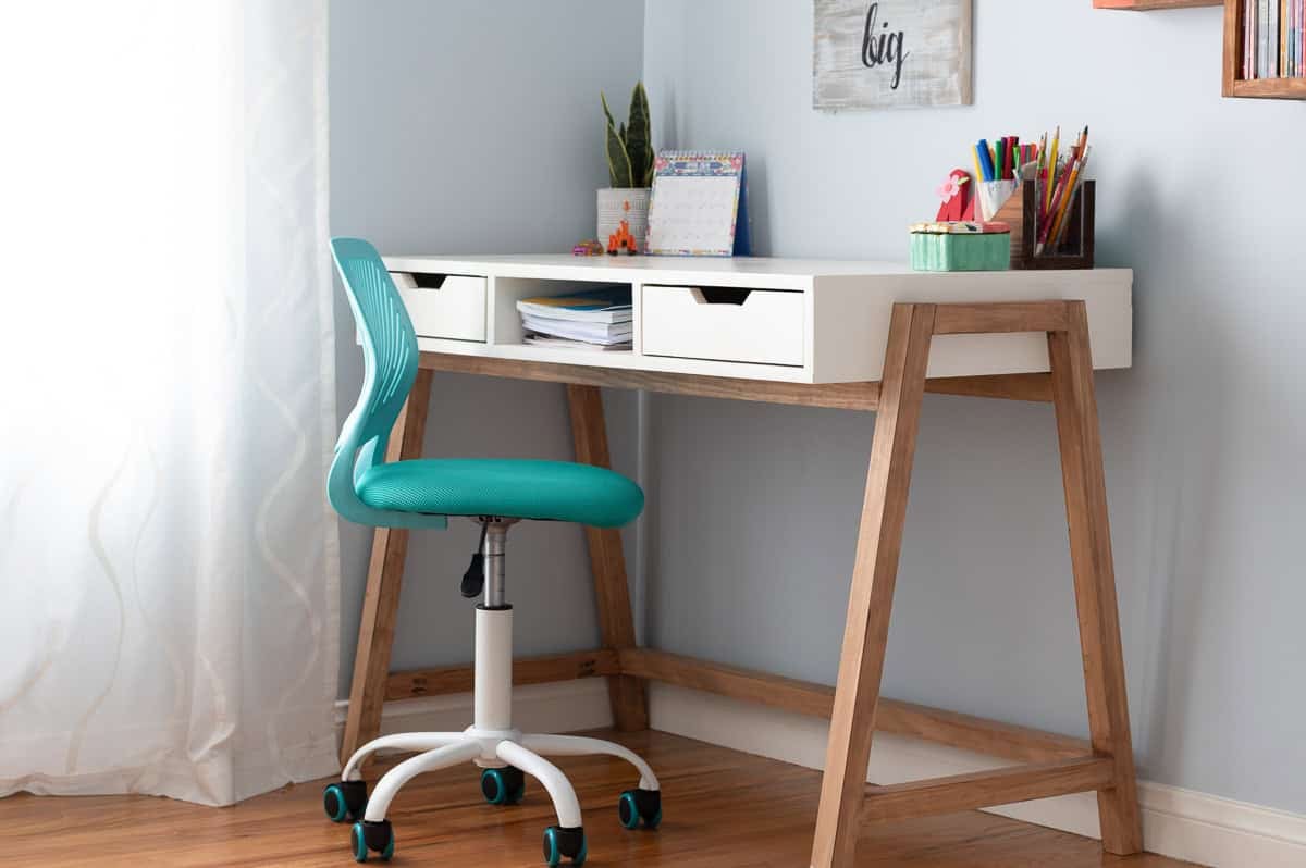 Modern A-Frame diy desk with office supplies on top and blue office chair in room with wood floors.