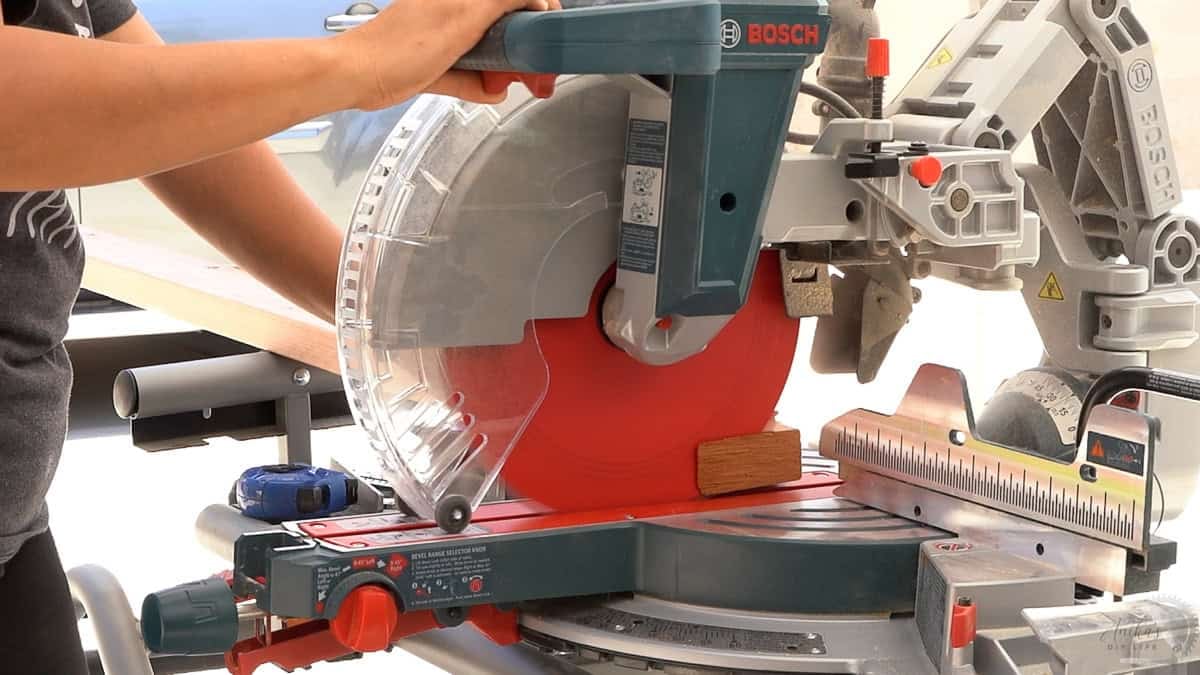 cutting off the end of a board before making the cuts for a project on a miter saw