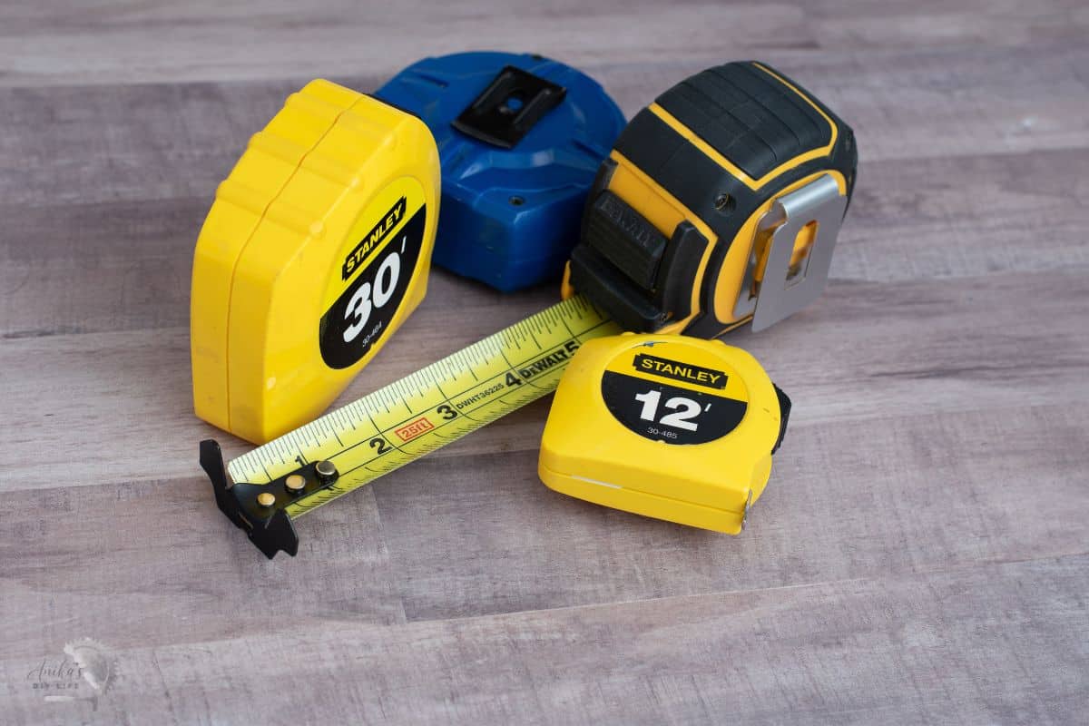 Four tape measures on a wood surface