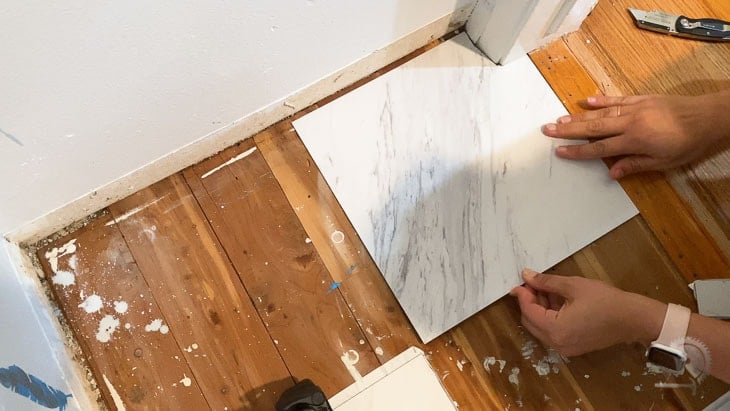 Woman installing peel and stick tile to the closet floor