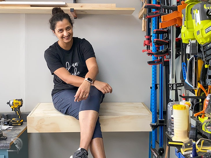 Woman sitting on floating shelf to test how strong it is