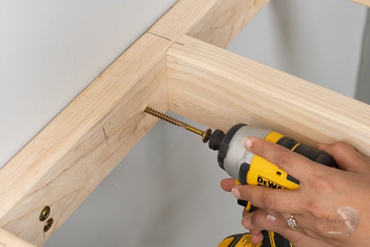 Attaching the floating shelf to the wall using a screw
