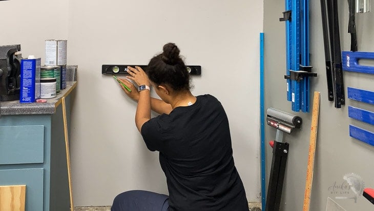 woman measuring location of the floating shelf