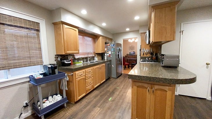 Before of kitchen with brown cabinets and dark floor