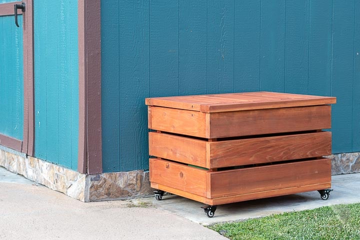 Wooden outdoor storage box with wheels.