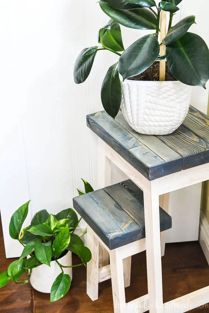 two DIY plant stands with dark painted tops