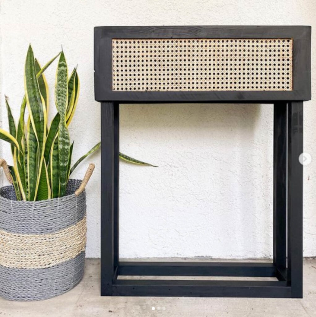 black painted wood plant stand with cane webbing