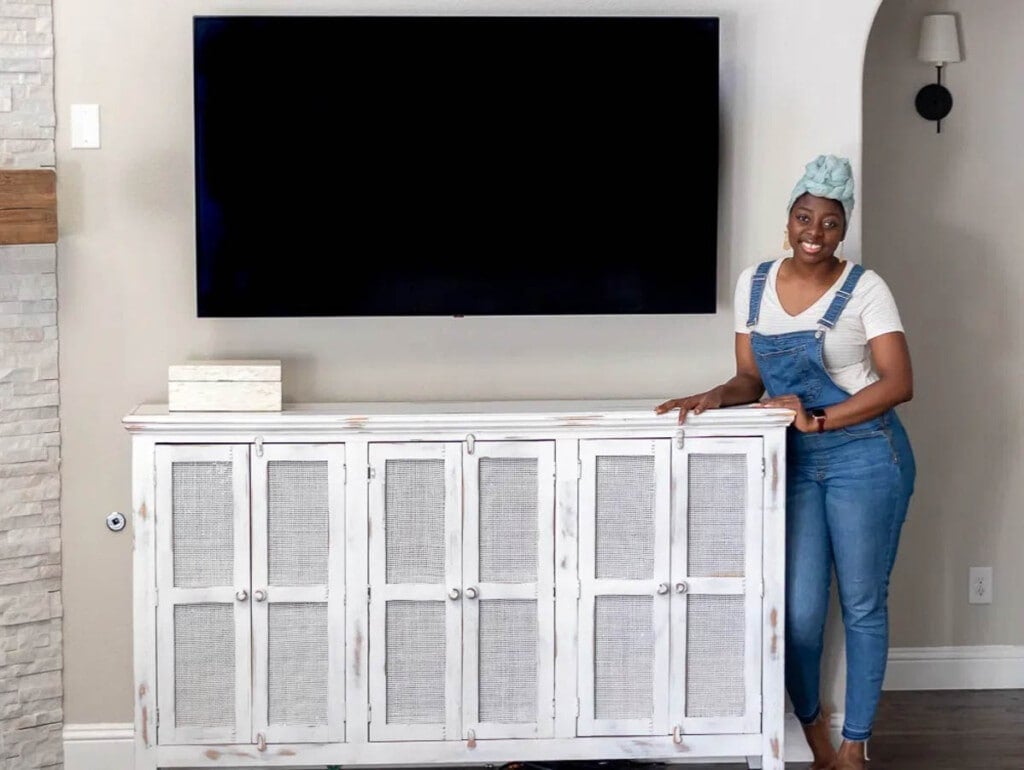 media console using cane webbing in the doors with woman leaning on the corner