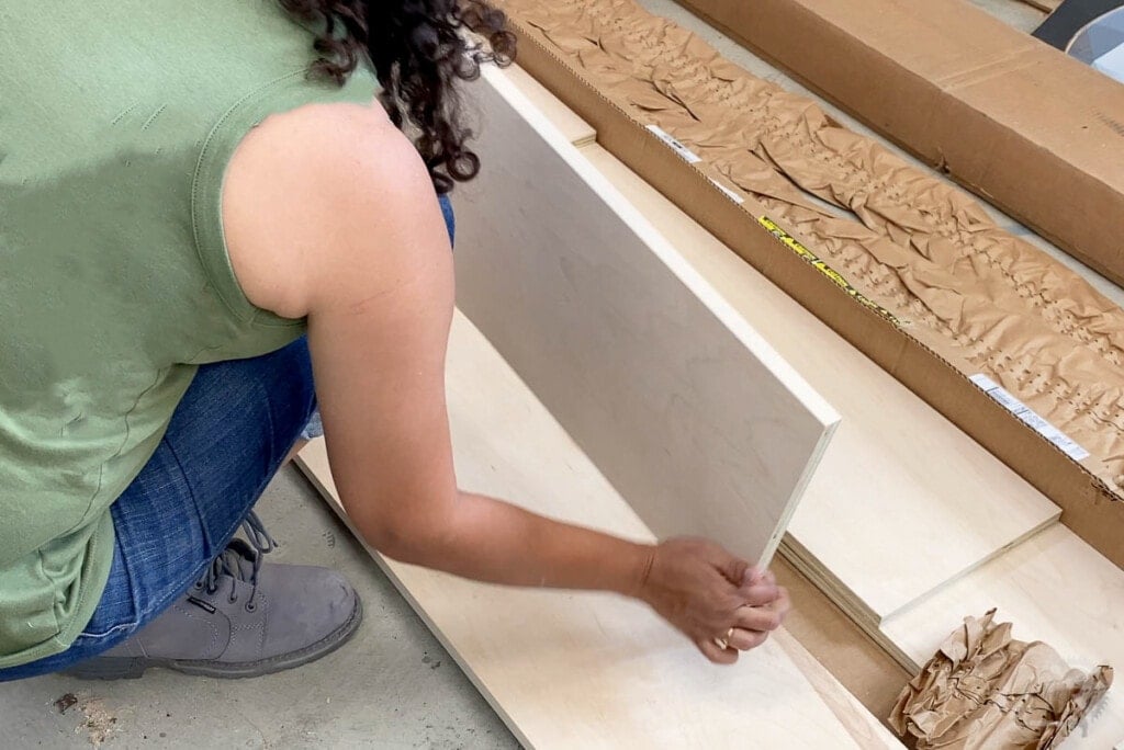 woman looking at boards from shelf help package