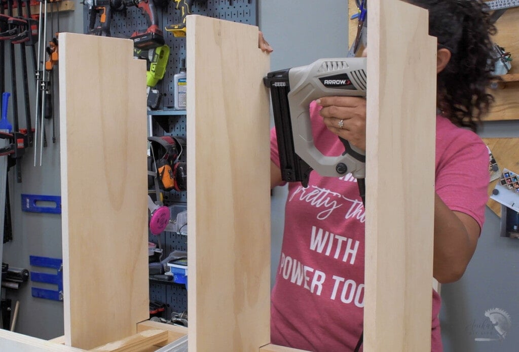 Woman attaching shelves to the DIY bookshelf