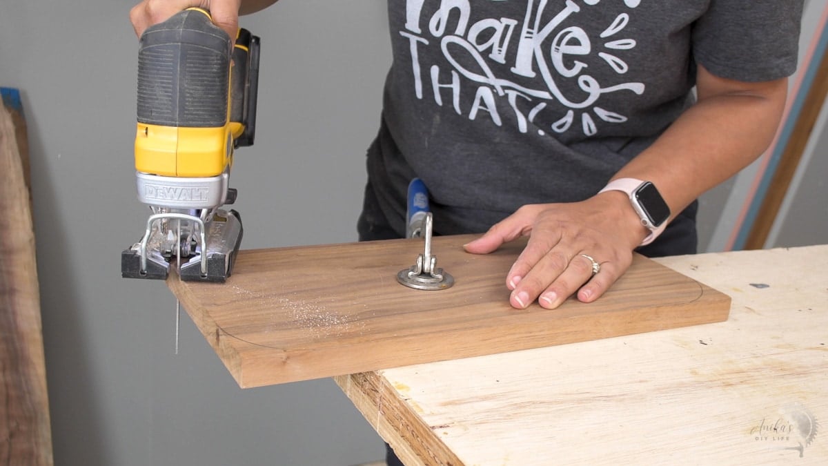 Woman cutting off corners of the cutting board with a jigsaw