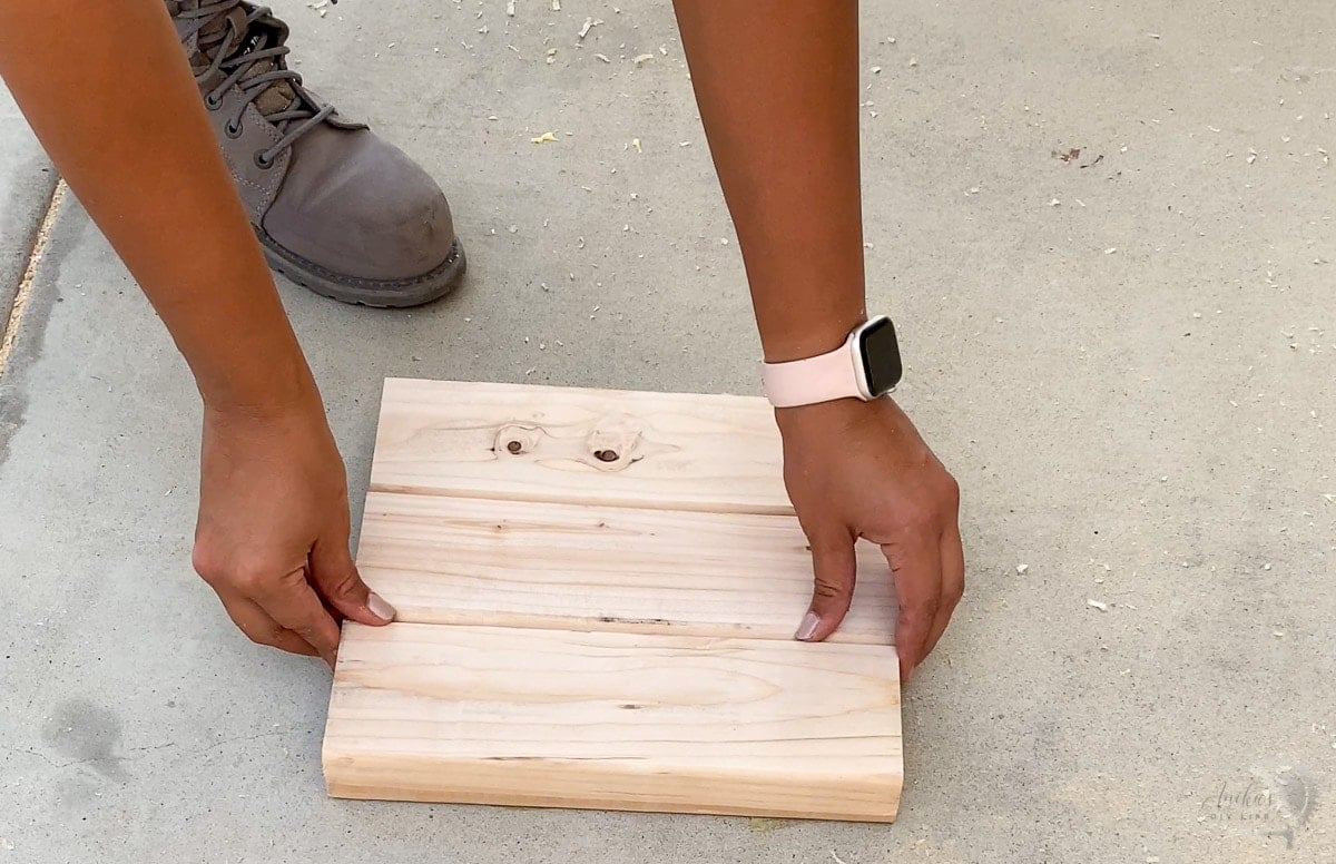woman lining up the boards for the bottom of the shelf