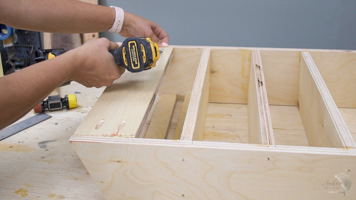 Woman attaching back support on the DIY sandpaper and sander organizer
