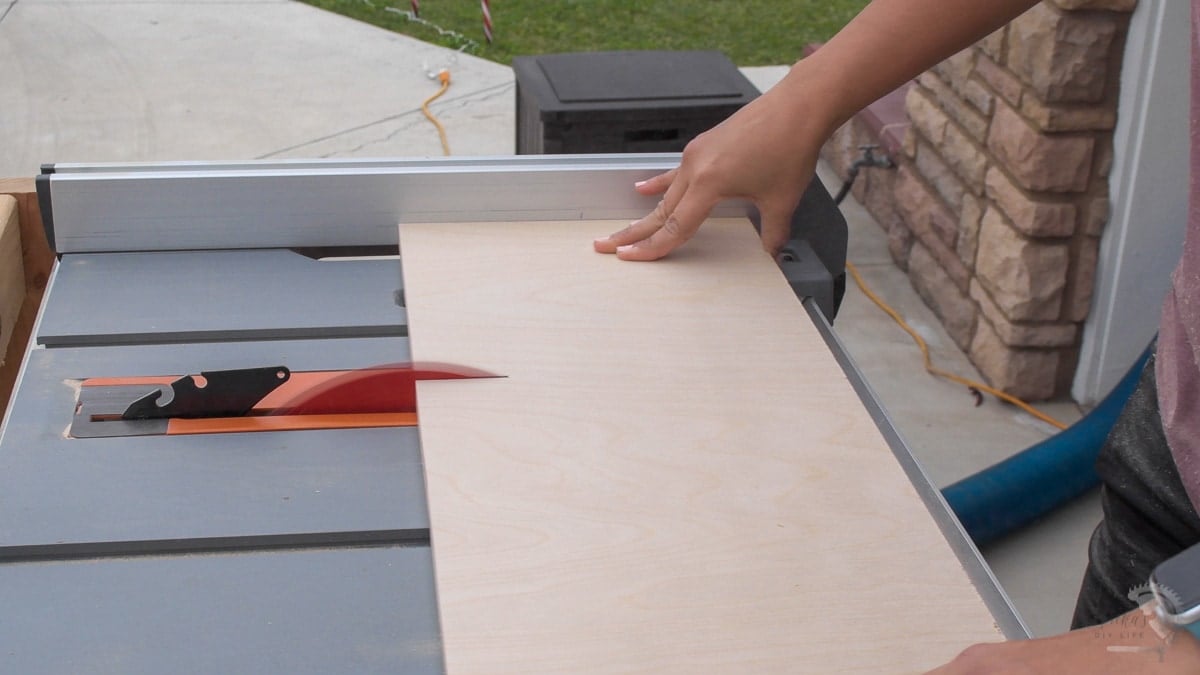woman cutting plywood on table saw