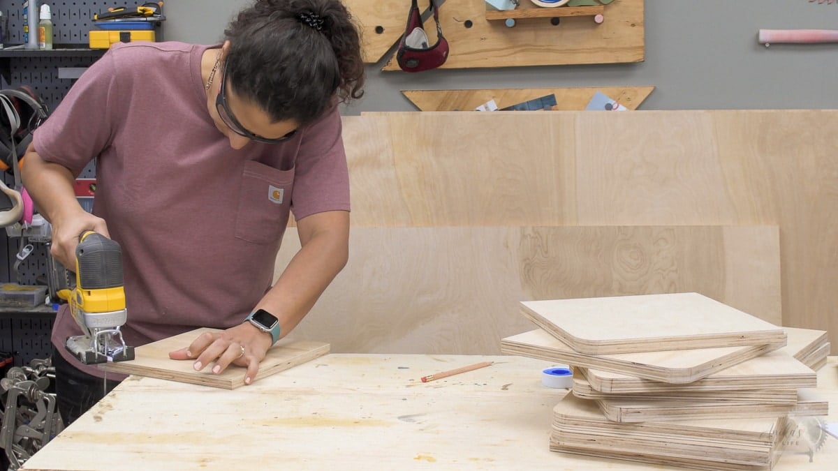 Woman cutting the corners of plywood using a jigsaw 