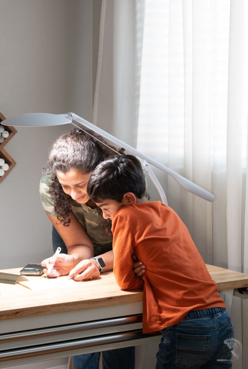 Woman and boy making a craft on table with Cricut Bright 360 on table