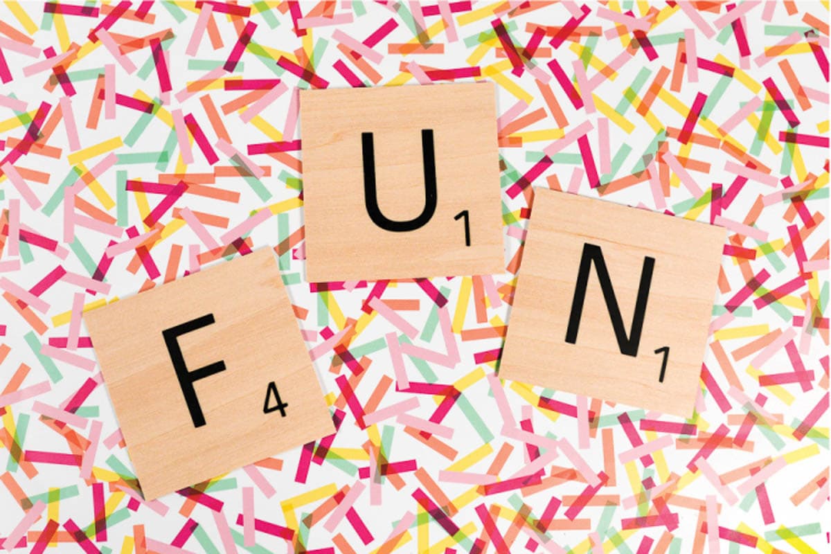Scrabble tiles spelling FUN laying on coloful background