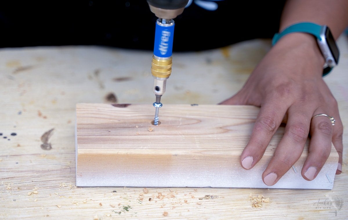 Woman adding pocket hole screw into a scrap board