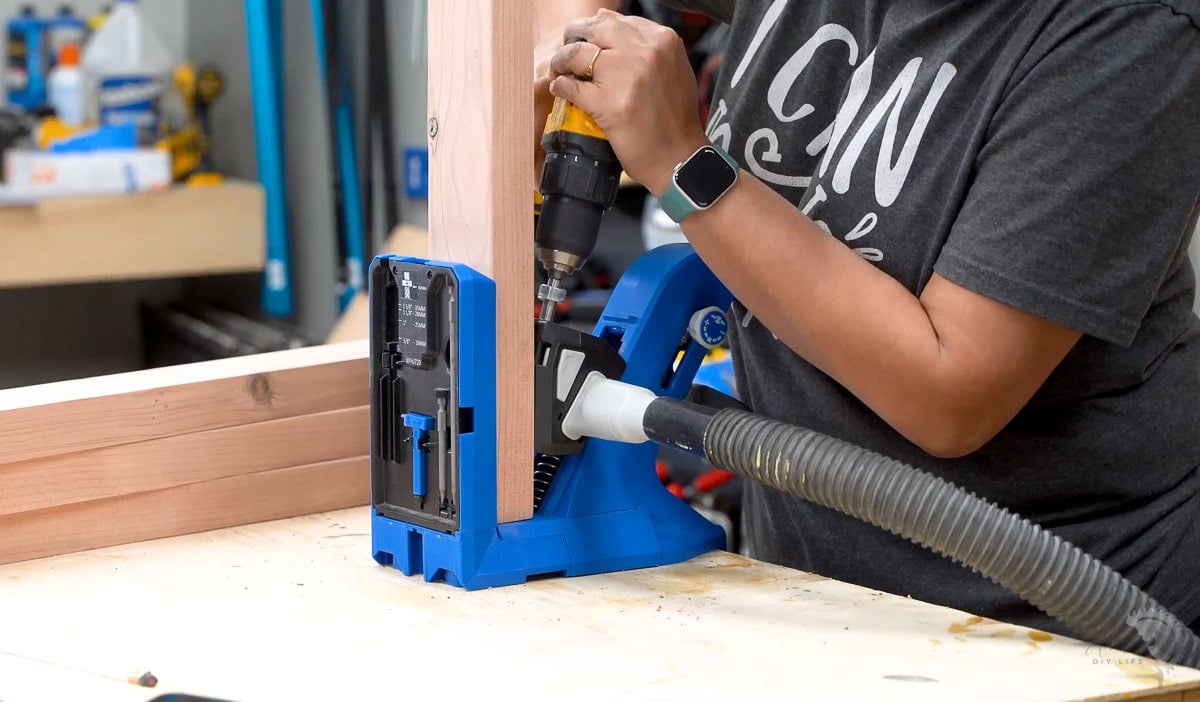 Woman making pocket holes in redwood boards with Kreg 720