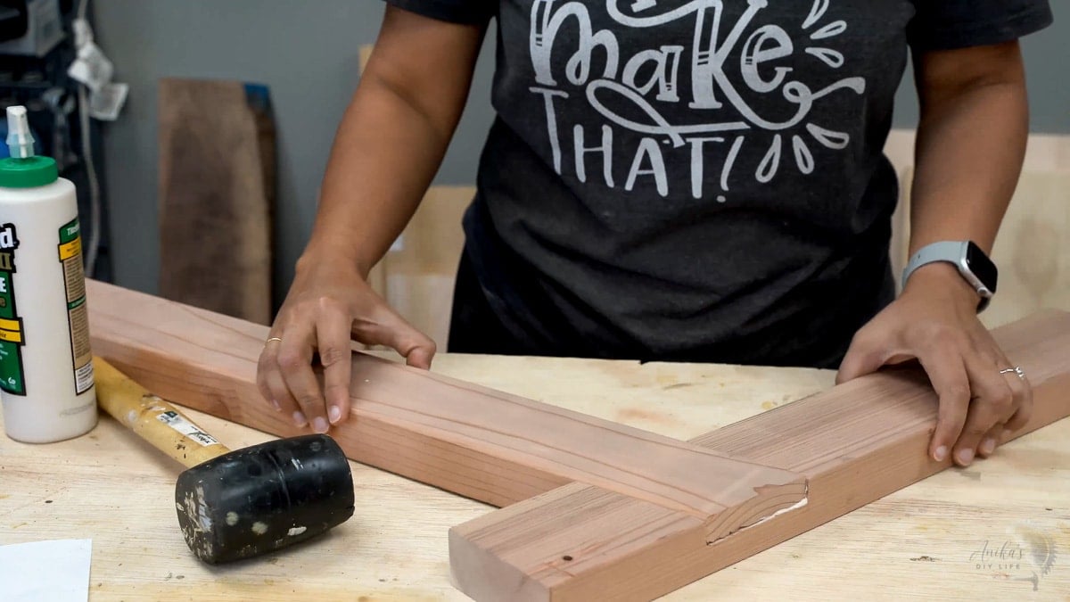 Woman fitting together a half lap cut on 2x4 to build a chair