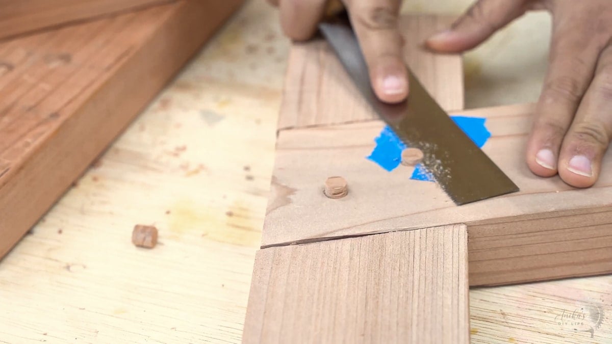 Cutting off plugs in the half lap cut using a japanese saw.