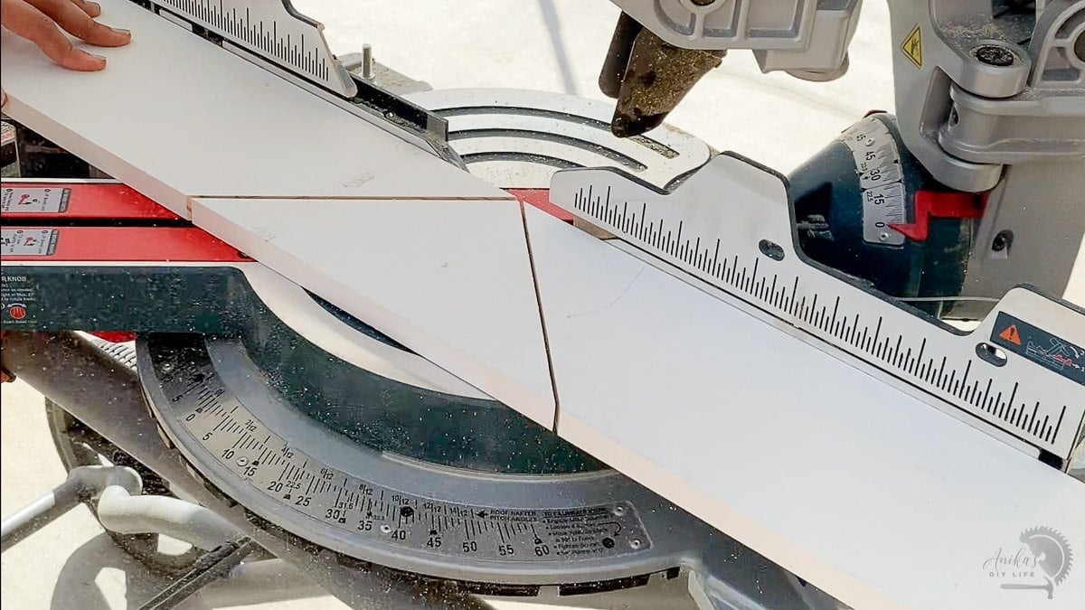 scrap board on miter saw with two cuts at 45 degree