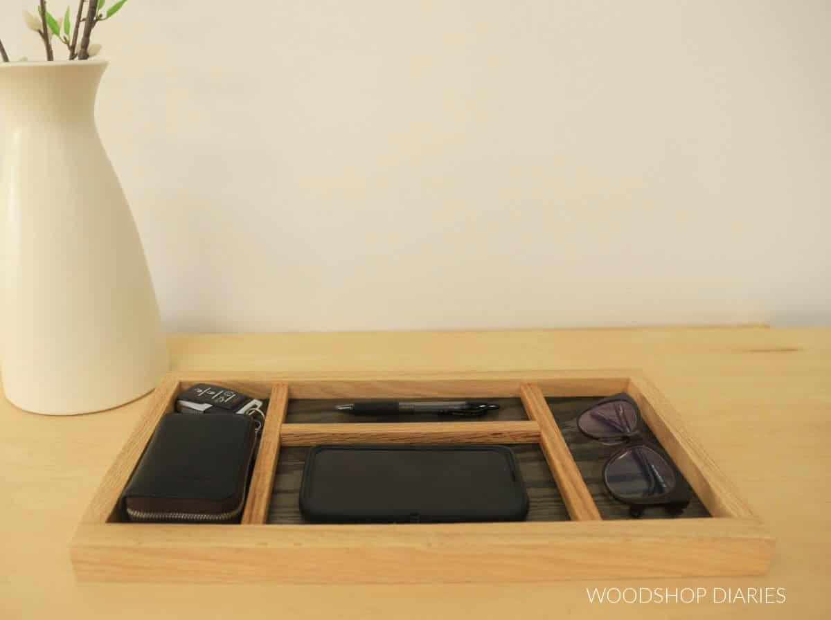 DIY wood catch all tray with phone, glasses, pen, and case in the sections