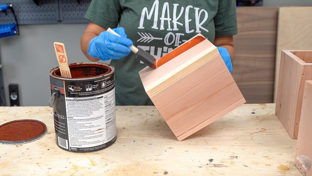 Vasos de Madeira DIY: Projeto Simples e Econômico para Iniciantes 11 mulher tingindo os vasos e floreiras DIY de madeira