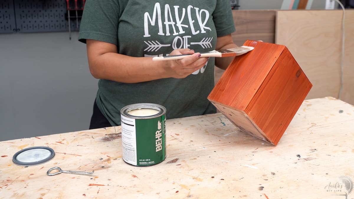 Vasos de Madeira DIY: Projeto Simples e Econômico para Iniciantes 15 mulher aplicando spar uretano no vaso e floreira